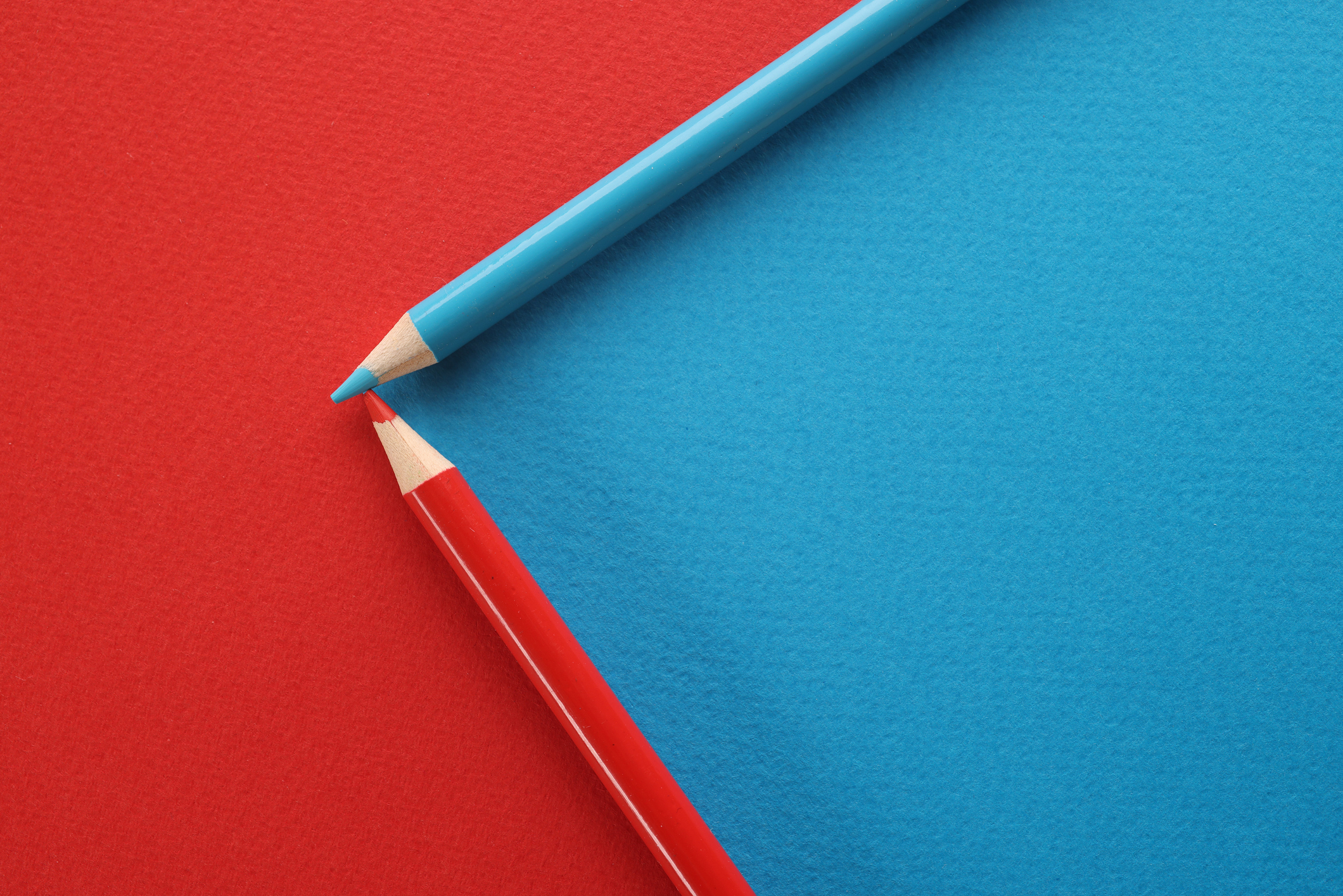 Blue and red pencils on red and blue background stock photo